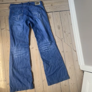 Lågmidjade jeans - Supersnygga lågmidjade jeans i bootcutmodell. Bakfickorna har små stenar. Perfekt skick! Midjan är som en L/XL och de är väldigt långa i benen. Skriv vid funderingar❤️Kolla gärna in alla mina andra jeans!