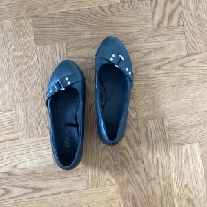 ballerina med kilklack - svarta ballerinaskor med låg kilcklack:) spänne uppepå och kilklacken är ca 3cm hög!