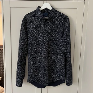 Blå småmöntrad skjorta - Mörkblå småmönstrad skjorta från Zara. Sparsamt använd och i mycket gott skick. L, men funkar på mig som är M/L. 