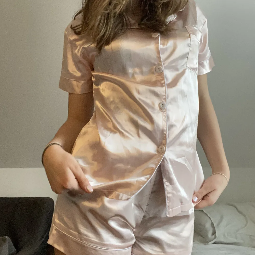 En jättefin och bekväm silkes pyjamas. Den är ljusrosa och har vita knappar! Säljer för den kom aldrig till användning. Priset kan diskuteras!. Shorts.