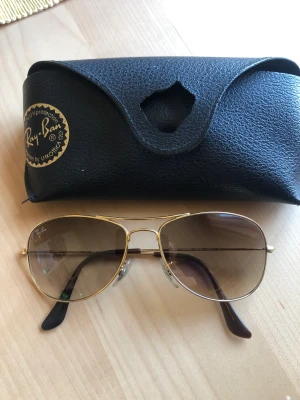 Rayban cockpit  - En nättare modell av de klassiska pilotbrillorna. Guldfärgade bågar. Fint skick. Endast fodralet är lite trasigt vid knäppet. 