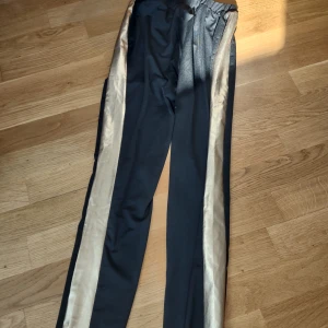 Byxor - Jätteskönta byxor som har en guldrand vid sidan.