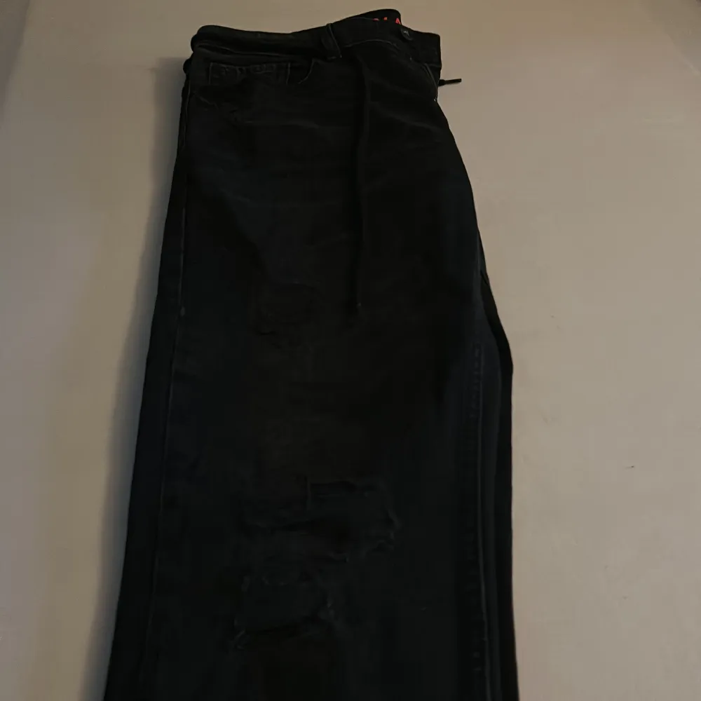 Snygga svarta jeans med slitningar, slitningarna är menade att vara på jeansen . Jeans & Byxor.