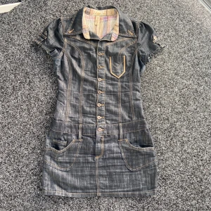 Denim Mini Dress (jeansklänning)  - Hejhej! Säljer min SKITSNYGGA jeansklänning då den tyvärr har blivit för tajt för mig 💔Klänningen ser som ny ut, utan några defekter. Den har dessutom jättefina detaljer på bakfickan som ni kan se på tredjebilden, ÄLSKAR! Skriv om du har några frågor 🥰🥰