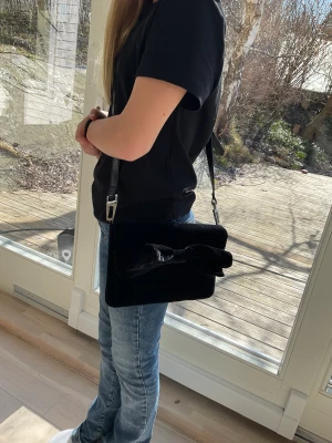 Sammets väska - Säljer denna super söta sammets väskan med rosett på💕 bandet tillkommer ej men är lätt att fixa. Skriv för frågor och/eller fler bilder💗💗💝villig att diskutera pris vid snabb affär