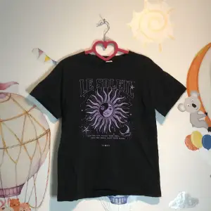 Jätte fin svart-lila t-shirt med en sol på 🌞💜 Med text på ” Le soleil, let the sun warm your soul and the moon ease your mind ” storlek 158/164 ålder 12-14. Från Lindex