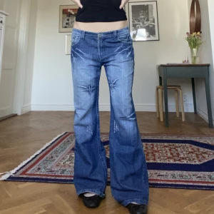 Lågmidjade flared jeans med broderier - Storlek S/M. Jag är 175. Innerbenlängd cirka 85 cm