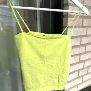 Linne - Säljer ett gult/neongult linne med spagetti snören.  Endast använd en kväll, så i ett mycket fint skick. Färg: Gul/Neongul Storlek: M