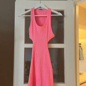 Kort rosa klänning, öppen i sidorna samt ryggen. Aldrig använd endast provad. Från Bershka i storlek S