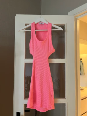 Klänning Mini - Kort rosa klänning, öppen i sidorna samt ryggen. Aldrig använd endast provad. Från Bershka i storlek S
