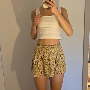 tygshorts - blommig tygshorts från urban outfitters som passar strlk xs/s men har resår i midjan oxå så man kan säkert gå upp i strlk. mjukt fladdrigt material så det ser ut som en kjol men är i själva verket shorts. 🤍