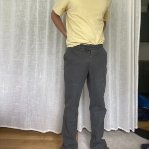 Kostym byxor i jeans tyg - Kostym byxor i grått jeans tyg! Fina raka!   Innerben 83cm, midja mätt rakt över 45, ben öppning mätt rakt över 23cm.  Modell:183cm lång 