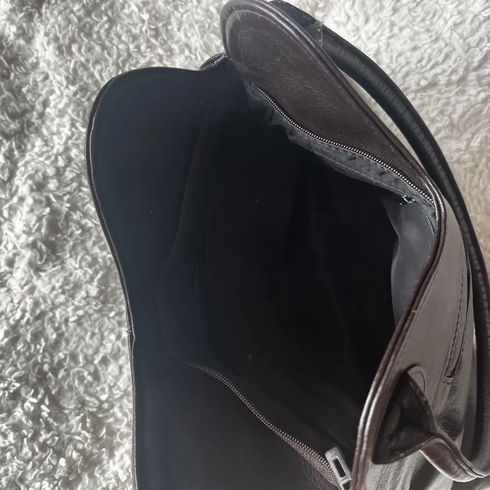Med sorg i hjärtat säljer jag nu denna handväska då jag håller på att rensa garderoben. Passar perfekt som skol/vardags-väska, har flera fack och är antagligen i äkta läder. Färgen är brun-svart i verkligheten.. Väskor.