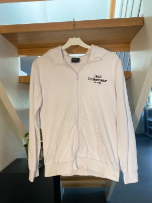 Peak performance jr original zip hoodie - Säljer en vit peak performance jr original zip hoodie i storlek 160! Tröjan jag en brodyr logga på vänster bröst. Säljer pga för liten ! Nypris 799kr mitt pris 149kr