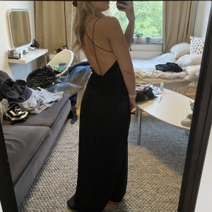 Balklänning - Svart balklänning med ”öppen” rygg och slits där fram. Skulle säga att den passar de flesta storlekar