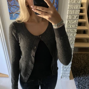 Glittrig kofta  - Grå glittrig kofta med knappar, köpt i Danmark. Storlek s.