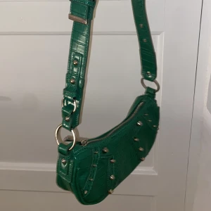 Väska - En fin grön väska med silvriga detaljer köpt på asos💚