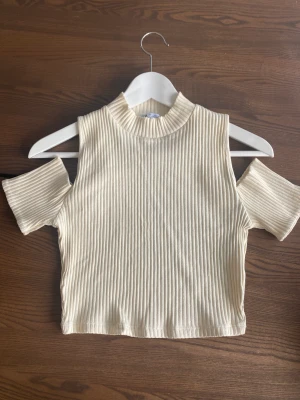 Ribbad zara topp - Säljer denna fina krämfärgade stickade topp från Zara med vit outs vid axlarna! 💕 Aldrig använd i storlek S.