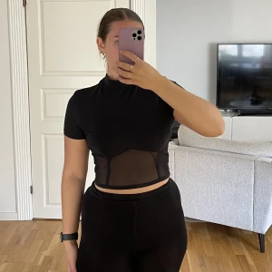 Tröja med mesh  - Svart T-shirt med halvpolo och mesh detalj 