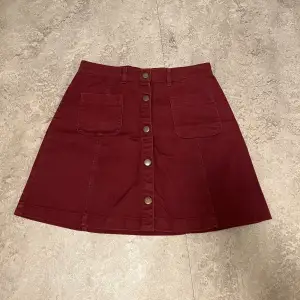 Vinröd kjol med tryckknappar från Monki. Använd några gånger men är i fint skick!