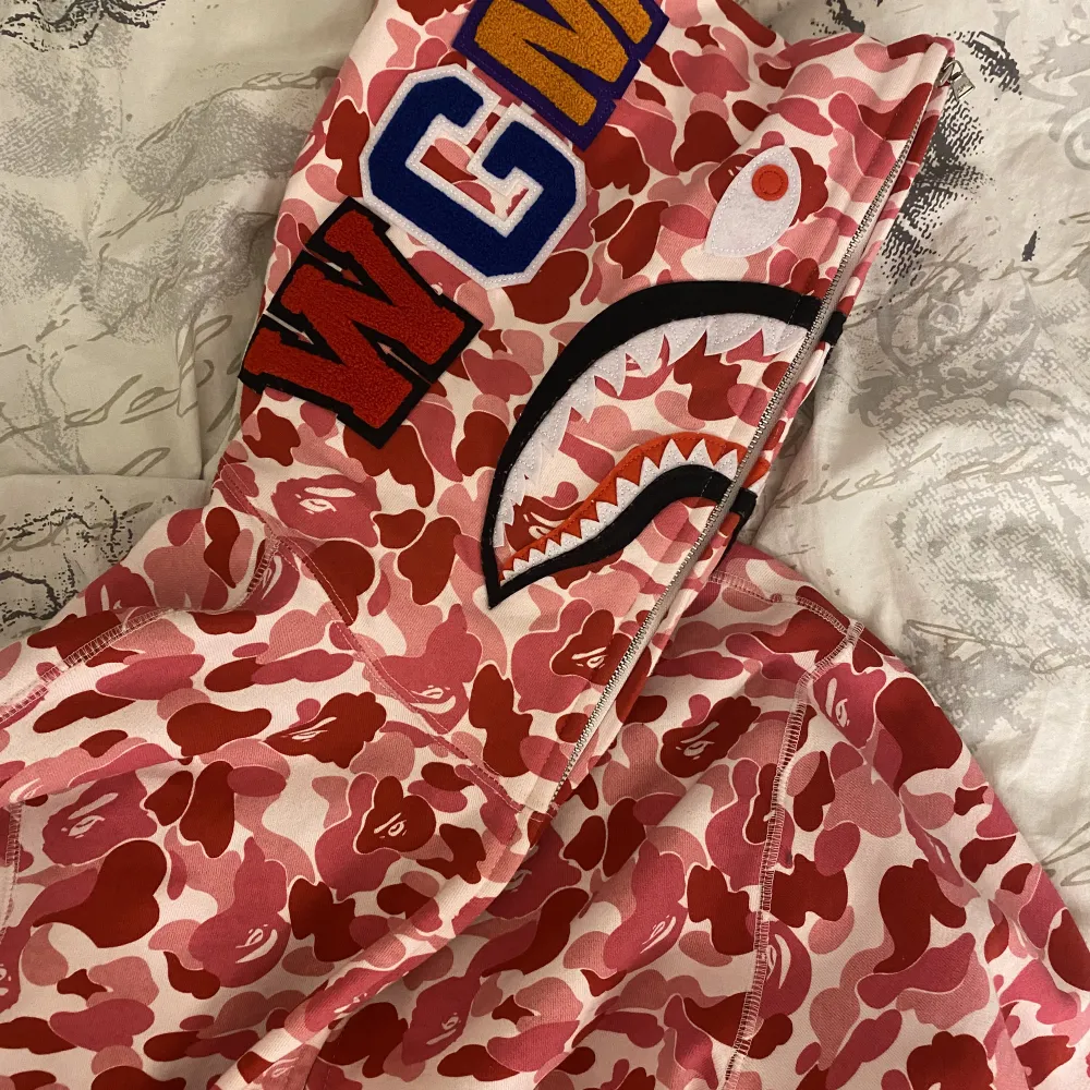 Rosa bape hoodie i nyskick, jag fick den i present så vet inte om den är äkta men den ser likadan ut som en riktig, inte min stil längre därför säljer jag! (Skriv om du har några frågor). Hoodies.