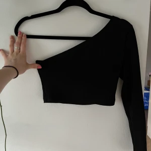 Svart enarmad topp - Svart enarmad topp från SHEIN, är kort på mig därav använder jag den inte. 