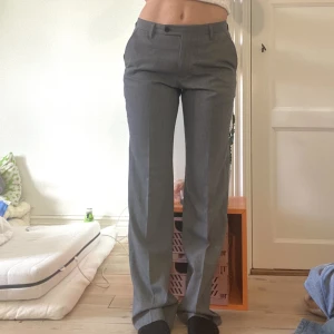 Lågmidjade Striped kostymbyxa - Grå, vita stripes. Lågmidjade, Innebenslängden cirka 83 cm. Midja cirka 80-85 cm. Märke Riley. Inga defekter.