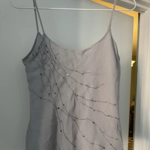 Superfint linne - Grått linne i lite mesh-aktigt material. Fina pärldetaljer. Bra skick!