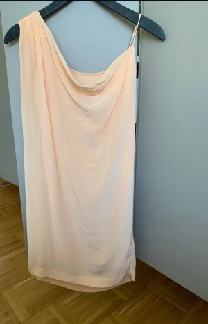 Klänning 36 Tiger of Sweden - One shoulder  klänning från Tiger af Sweden, fodrat. Ej genomskinlig  Färg: persika/orange pastell Ny med prislappen kvar 