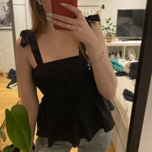 Svart topp med volang  - Säljer min jättesöta svarta topp då den är alldeles för tajt för mig vid bysten 🥲Använd kanske 1 gång så den är i ett bra skick 