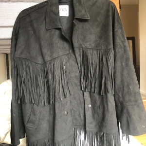 Jacka med fransar  - Svart jacka i mockamaterial med fransar! Storlek xs men känns större då den är oversized 