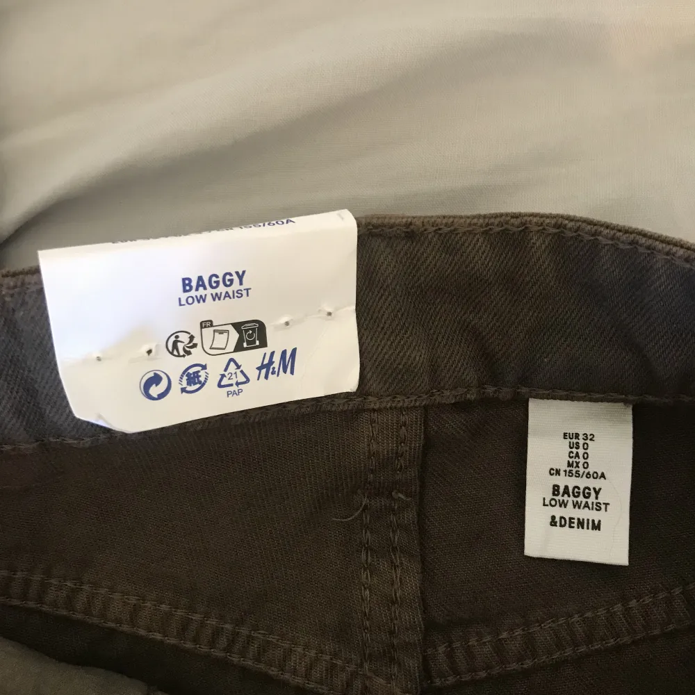 Säljer dessa bruna baggy jeans från H&M i storlek 32. Står att dom är low waist men dom sitter mer dom mid waist! Aldrig använt och lappen är fortfarande kvar så dom är i mycket bra skick! Ordinarie pris=299. Jeans & Byxor.