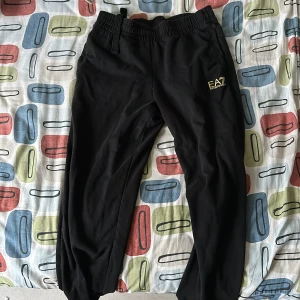 EA7 Mjukis Byxor - Super sköna och snygga EA7 byxor i svart och guld. byxan köptes för ett tag sedan men används runt 5 gånger. 9.5/10 skick. Köptes för 800