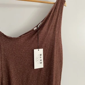 One shoulder finstickad maxiklänning med ringdetailj - Köpte klänningen för ett tag sedan och trodde att jag skulle använda den. Tyvärr blev det ej så. Den har hängt inne i min garderob med etiketterna kvar där på. Helt oanvänd klänning från NA-KD. Finns bilder med klänningen på på deras hemsida🤎💛