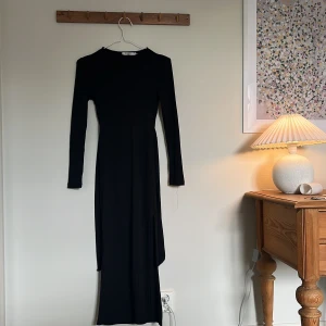 Svart Långklänning  - En svart långklänning som är öppen i ryggen från NA-KD. Klänningen är i storlek xs men skulle säga att den även passar s. Endast använd en gång så väldigt bra skick! Säljes då den inte kommer till användning💗slits nedtill 