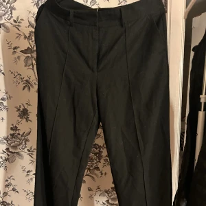 Kostymbyxor  - Kostymbyxor med medelhög midja från NA-KD. Är en slits längst ner på byxans ben. Använt fåtal gånger och byxorna är i ett bra skick. 
