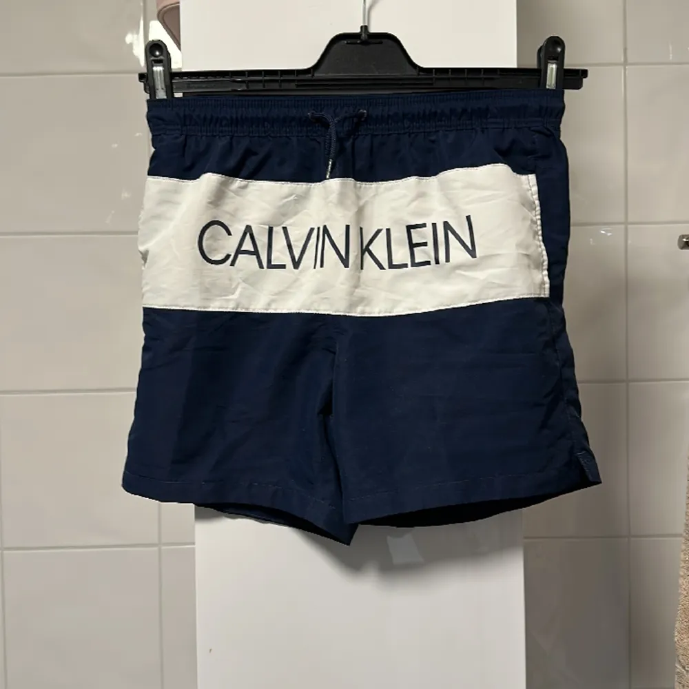 Badbyxor från Calvin Klein i storlek 12/14 i marinblå och vit . Shorts.
