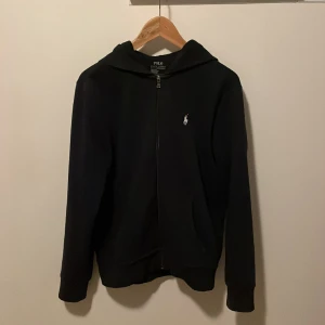 Ralph Lauren hoodie  - Hej! Jag säljer nu min mörkblåa Ralph Lauren hoodie på grund av att den blivit för liten för mig. Nypris 1600 kr, Skick 7/10 (saknar snören). Hör av dig vid frågor och funderingar!