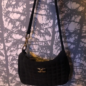 Väska - En svart basic svart väska. Med två små guld ditaljer.