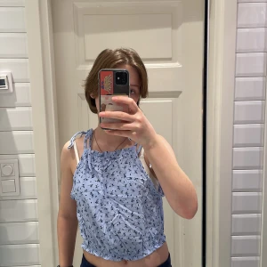 Ceoppad blus - Supersommrig croppad blus med små blommor på! Den är lätt att sätta på och passar perfekt till midsommar eller annat! Använd en eller två gånger och skicket är som ny! 