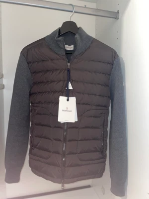 Moncler Cardigan grå - Moncler cardigan grå i storlek M men passar S också. Med fungerande scan och Nfc.(aldrig använd)