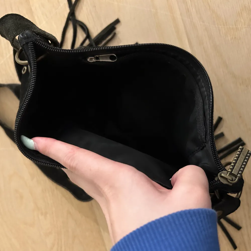 - En svart vintage väska med fransar och metal cirklar  - Använd med är i bra skick förutom inne facket som är trögt att stänga men inga problem att användas ändå🩷 - Pris kan diskuteras . Väskor.