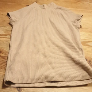 Beige kortärmad thight topp - En beige kortärmad topp med lite krage och den kan va ganska thight. Från ZARA.