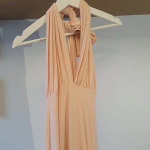 Oanvänd Finklänning / balklänning multiway - Rosa finklänning som kan knytas på flera olika sätt. Perfekt till bal, bröllop, finsittning eller liknande! Köpt från Boohoo. Lappar kvar, helt oanvänd💕 OBS, tråden har släppt lite i slitsen vilket var där från början, syns inte när man har den på sig