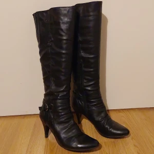 Höga klackerskor - Skorna är i stl 41.använda men i bra skick. Har en skada på ena skon som visas på den sista bilden och längst klackarna  är de lite skadade. 