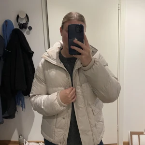 Beige dunjacka från Dobber  - Beige dunjacka från Dobber (köpt på MQ för några år sedan), så varm och mysig vinterjacka men kommer tyvärr inte till använding hos mig🤍Den är i storlek ”Small”, men passar xs-m beroende på önskad passform😊