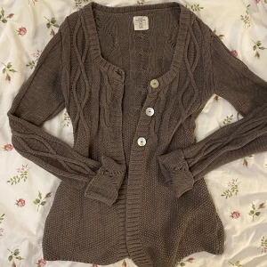 Brun lång kofta  - Det är en brun typ stickad kofta, är lite längre. Är storlek M men skulle säga att den är typ S om man viker upp armarna. Skriv vid fler frågor 💕