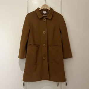 Brun fin kappa från Monki - Brun fin kappa från Monki, stor knappar och har fickor. Storlek XS! Använda med är i fint skick. 