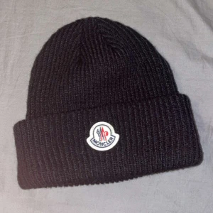 Moncler mössa svart  - En svart Moncler mössa som inte är använd kom privat för mer information 