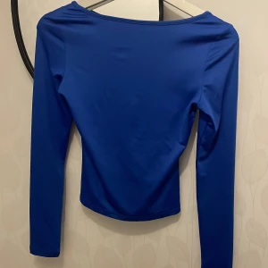 Blå långärmad t shirt - Säljer en skitsnygg blå långärmad t shirt i nyskick, endast använd en gång i storlek S💕